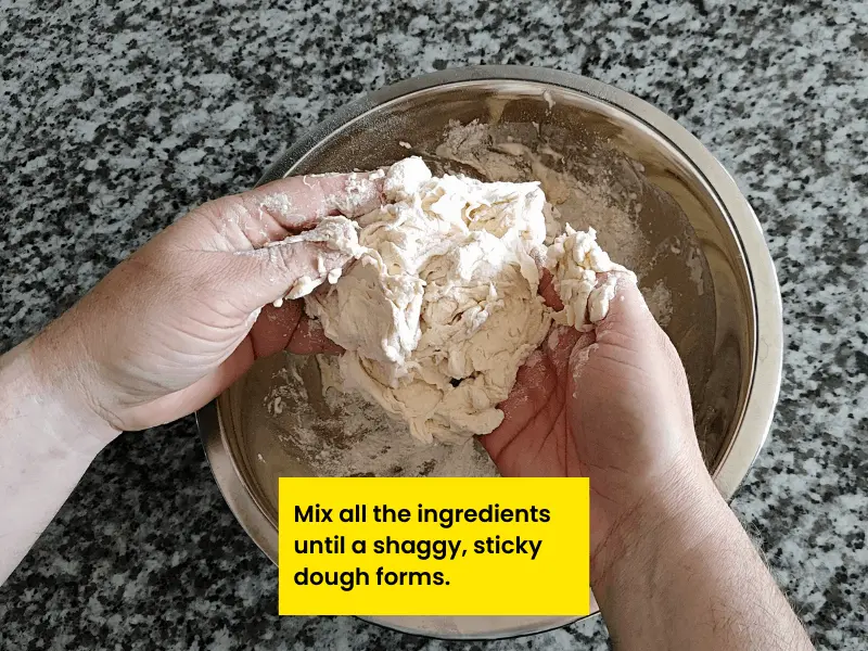 Mix the ingredients until a shaggy and sticky pizza dough forms.